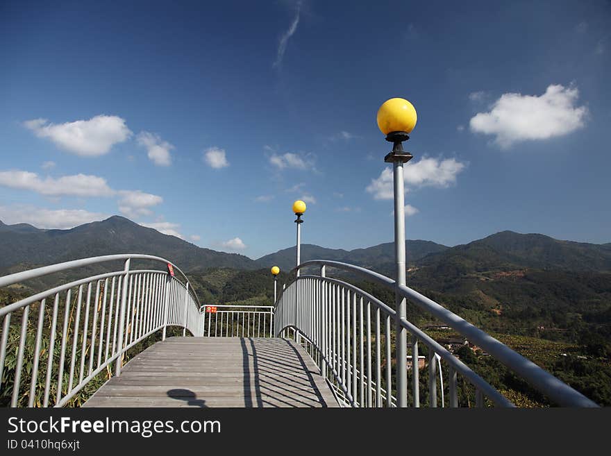 The steel bridge there is a line of street lamps on the bridge, the distance is a blue sky, and there is white cloud in the sky. The steel bridge there is a line of street lamps on the bridge, the distance is a blue sky, and there is white cloud in the sky.