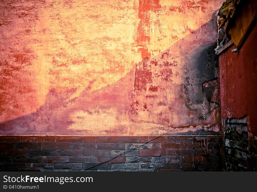 A weathered brick stone wall with red tint