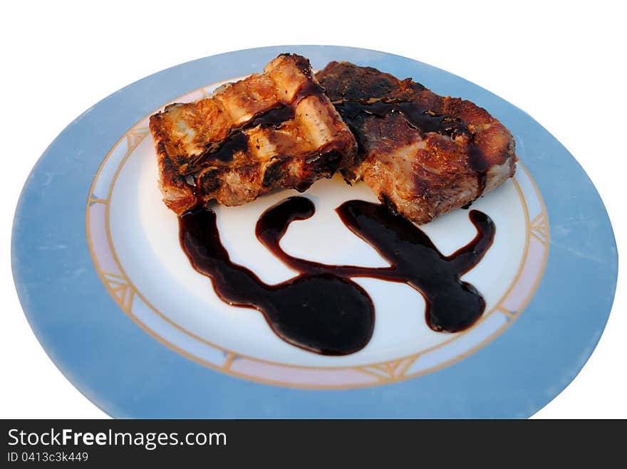 Grilled pork ribs whit sauce in a white dish