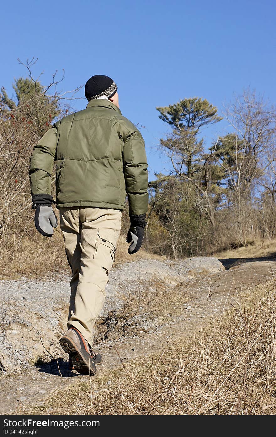 A man dressed for winter hiking climbs a trail through a wooded dune in January. Typically, there should be snow on the ground in Ontario at this time of year. A man dressed for winter hiking climbs a trail through a wooded dune in January. Typically, there should be snow on the ground in Ontario at this time of year