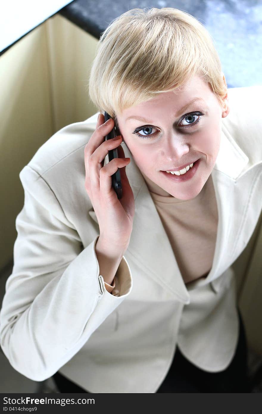 Image of a business lady on her mobile phone looking at you. Image of a business lady on her mobile phone looking at you