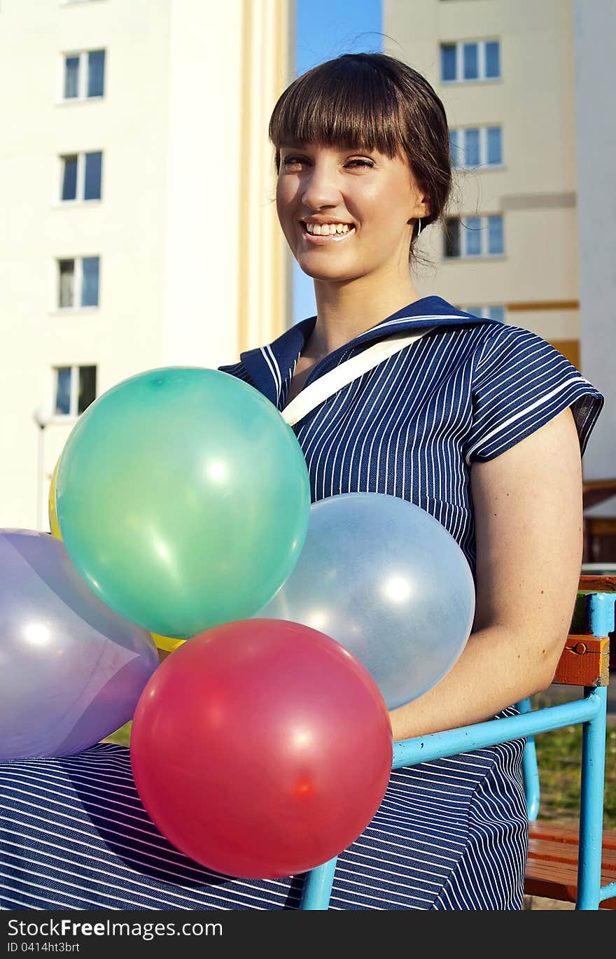 Beautiful happy girl holding balloons on the street. Beautiful happy girl holding balloons on the street