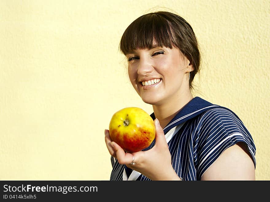 A beautiful girl  of the wall keeps apple