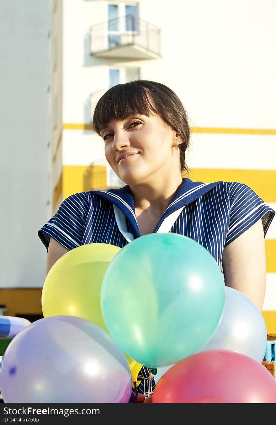 A beautiful girl on the swing is holding balloons. A beautiful girl on the swing is holding balloons