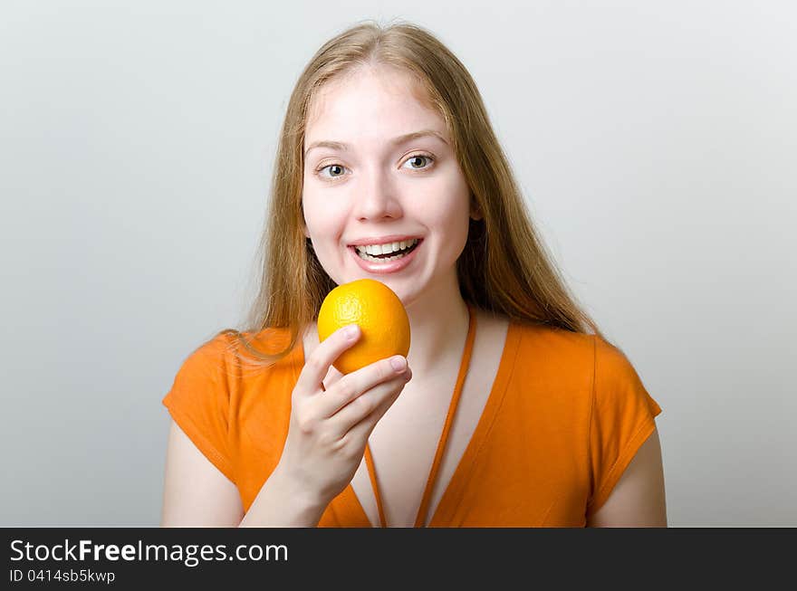 Cute blonde girl with an orange in her hand. Cute blonde girl with an orange in her hand.