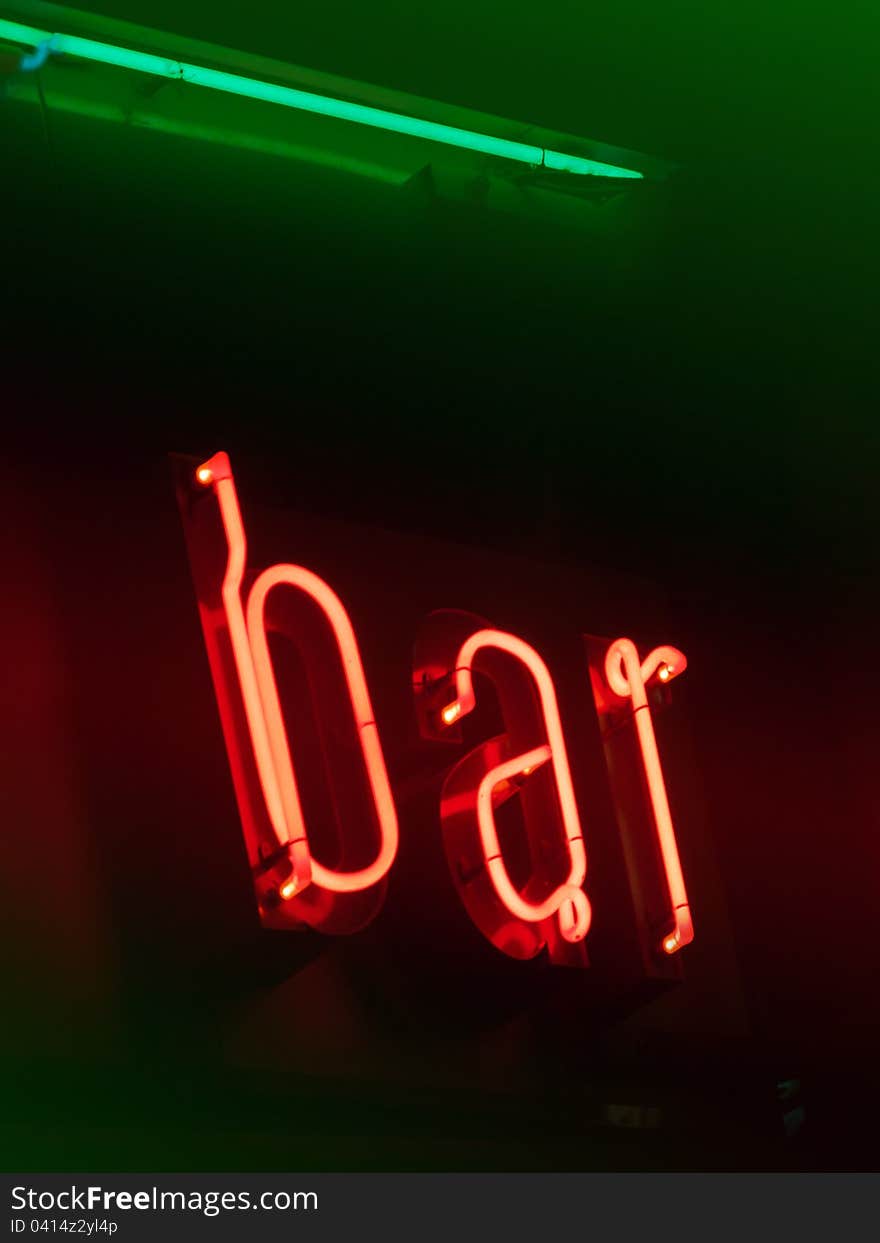 Red and green neon bar on brown signboard. Red and green neon bar on brown signboard