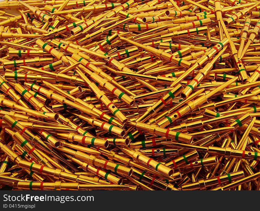 Golden plated electrical contacts of pin type with green and red rings. Golden plated electrical contacts of pin type with green and red rings