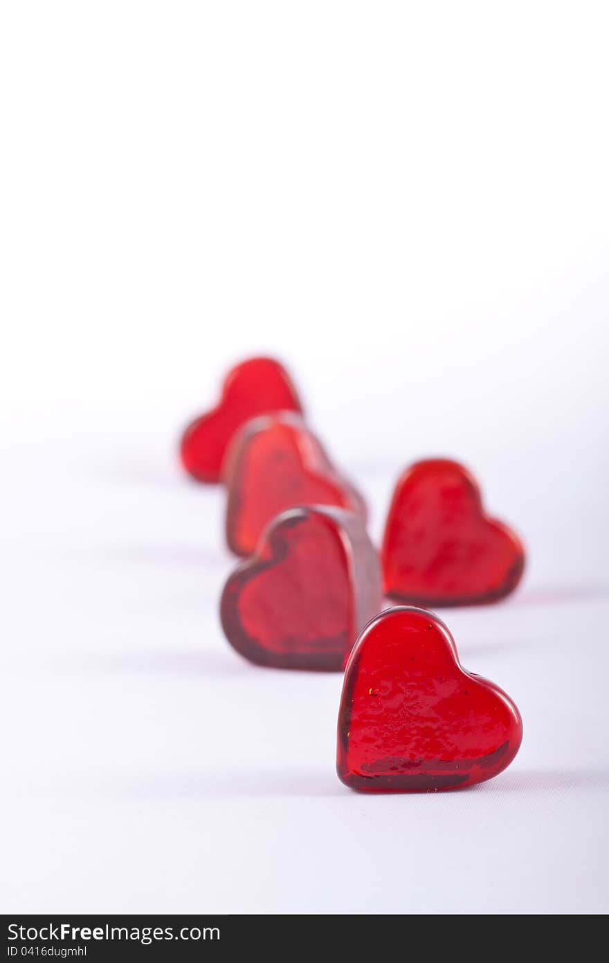 Five Glass hearts in portrait format with shallow depth of field.