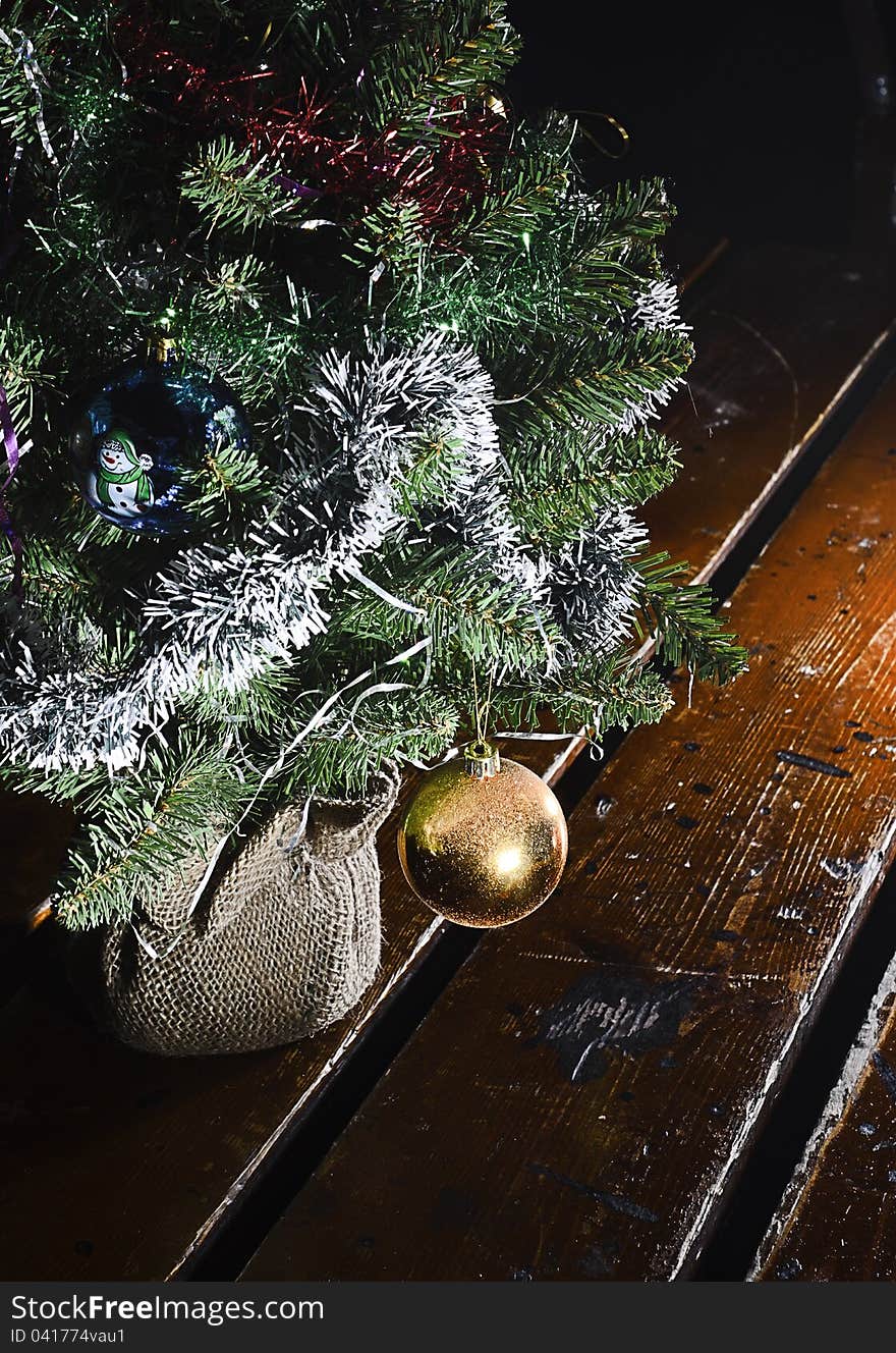 Decorative toy on a branch of a Christmas tree standing on the table