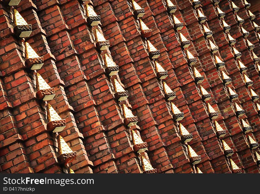 Brick wall with metal decoration of gold colour