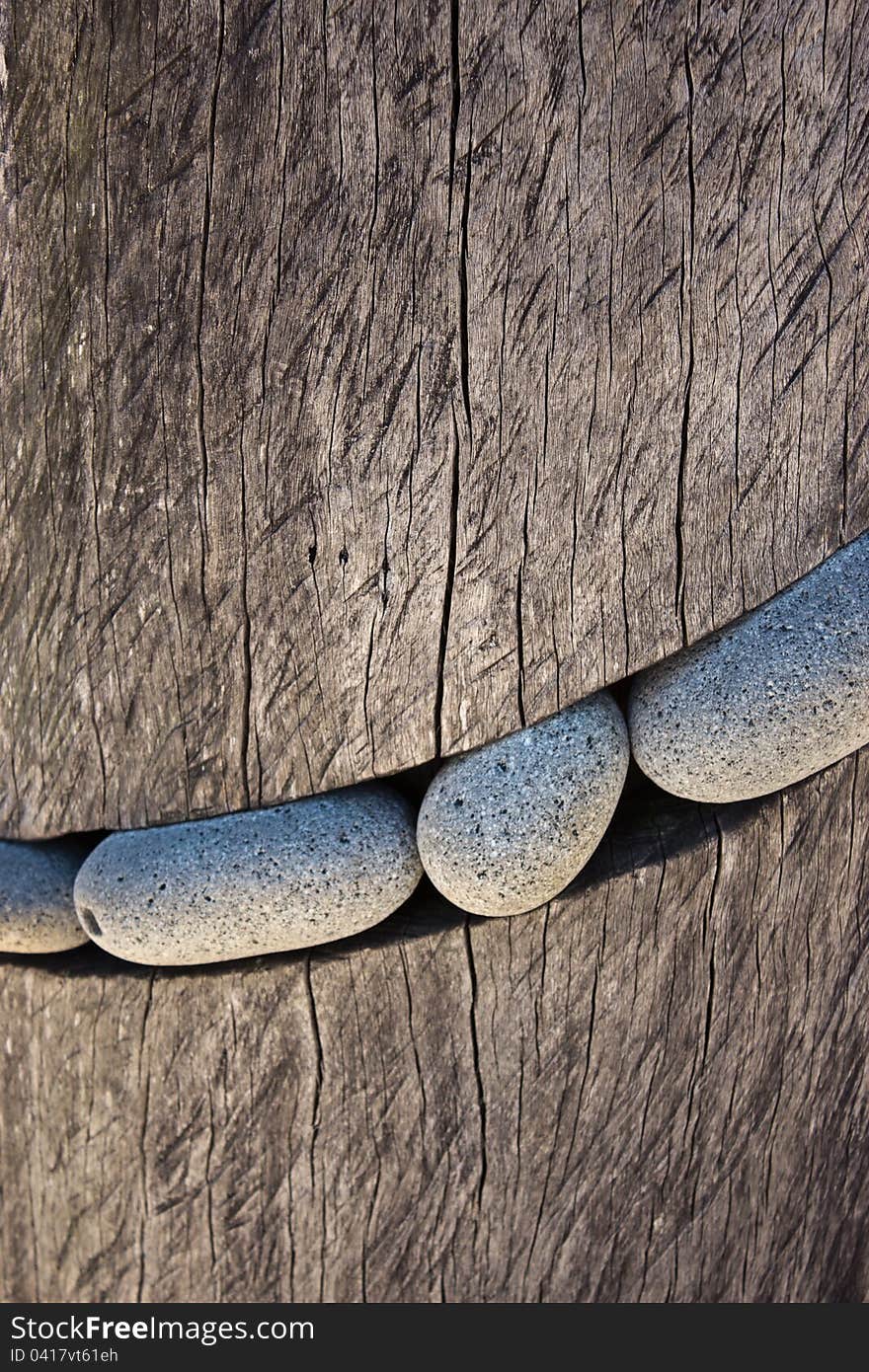 Smooth round stones carved into a block of wood. Smooth round stones carved into a block of wood