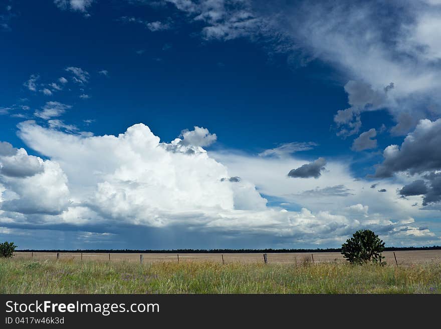 Blue sky with clouds over a field in the country. Blue sky with clouds over a field in the country