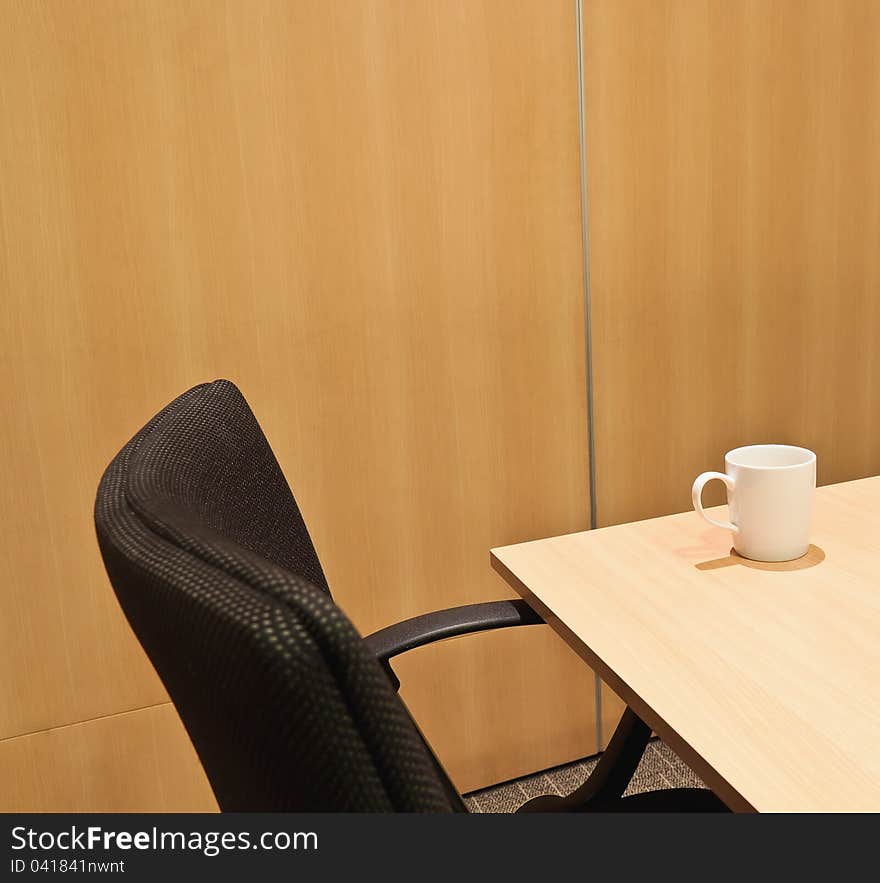 Cup of coffee on table in meeting room. Cup of coffee on table in meeting room