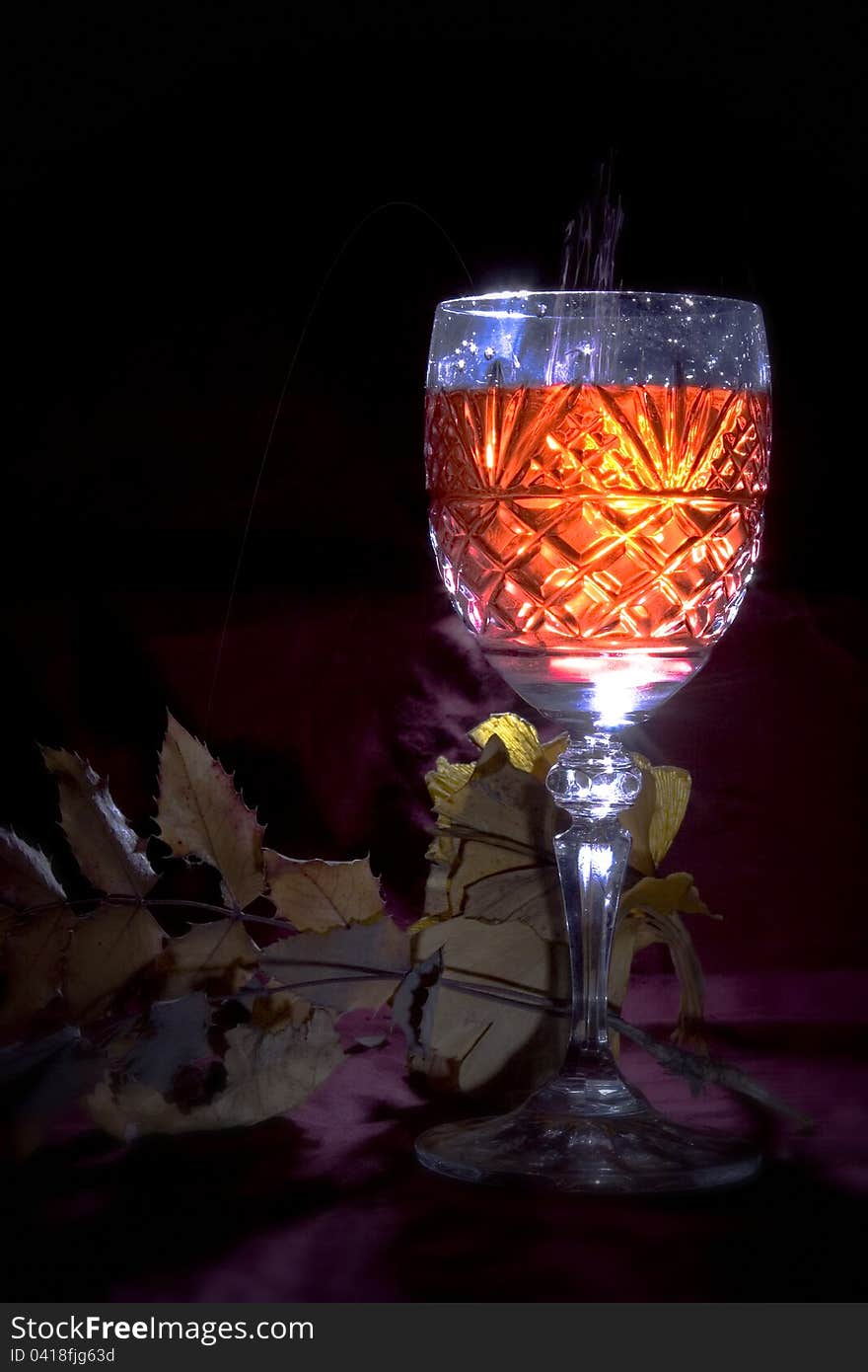 Crystal  wine glass with pouring wine and fall background