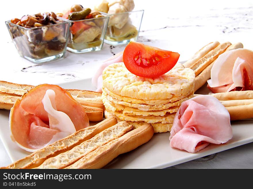 Deliciou composition whit ham prosciutto end tomato on the white background. Deliciou composition whit ham prosciutto end tomato on the white background