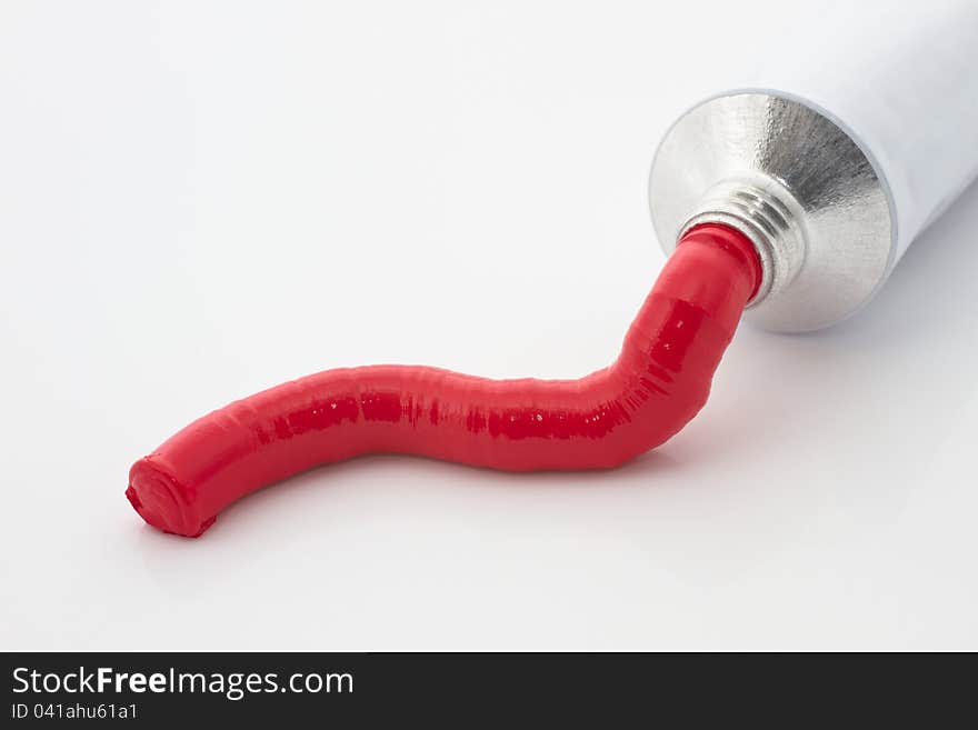 Red paint tube on a white background