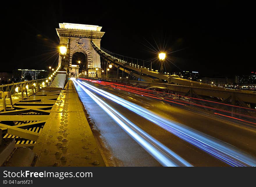 Traces of car headlights across the bridge