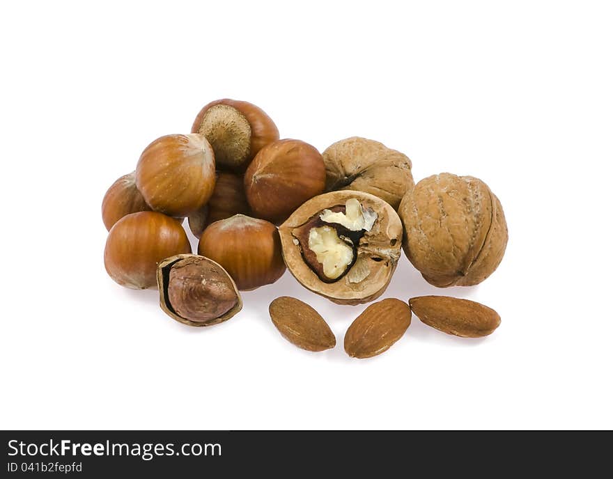 Walnut, filbert, almond by a mineral deposit on a white background. Walnut, filbert, almond by a mineral deposit on a white background