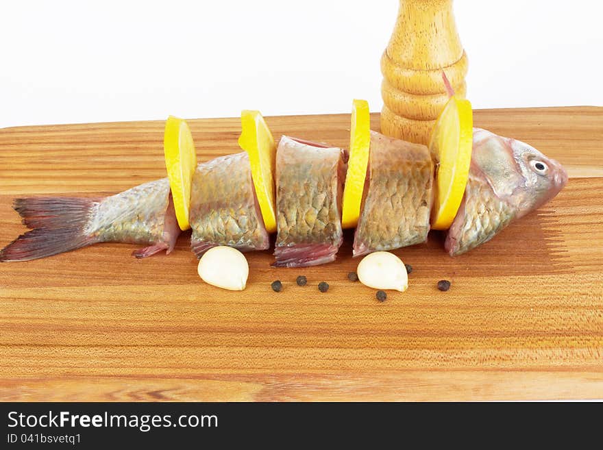 Raw fish with cooking ingredients on a cutting board