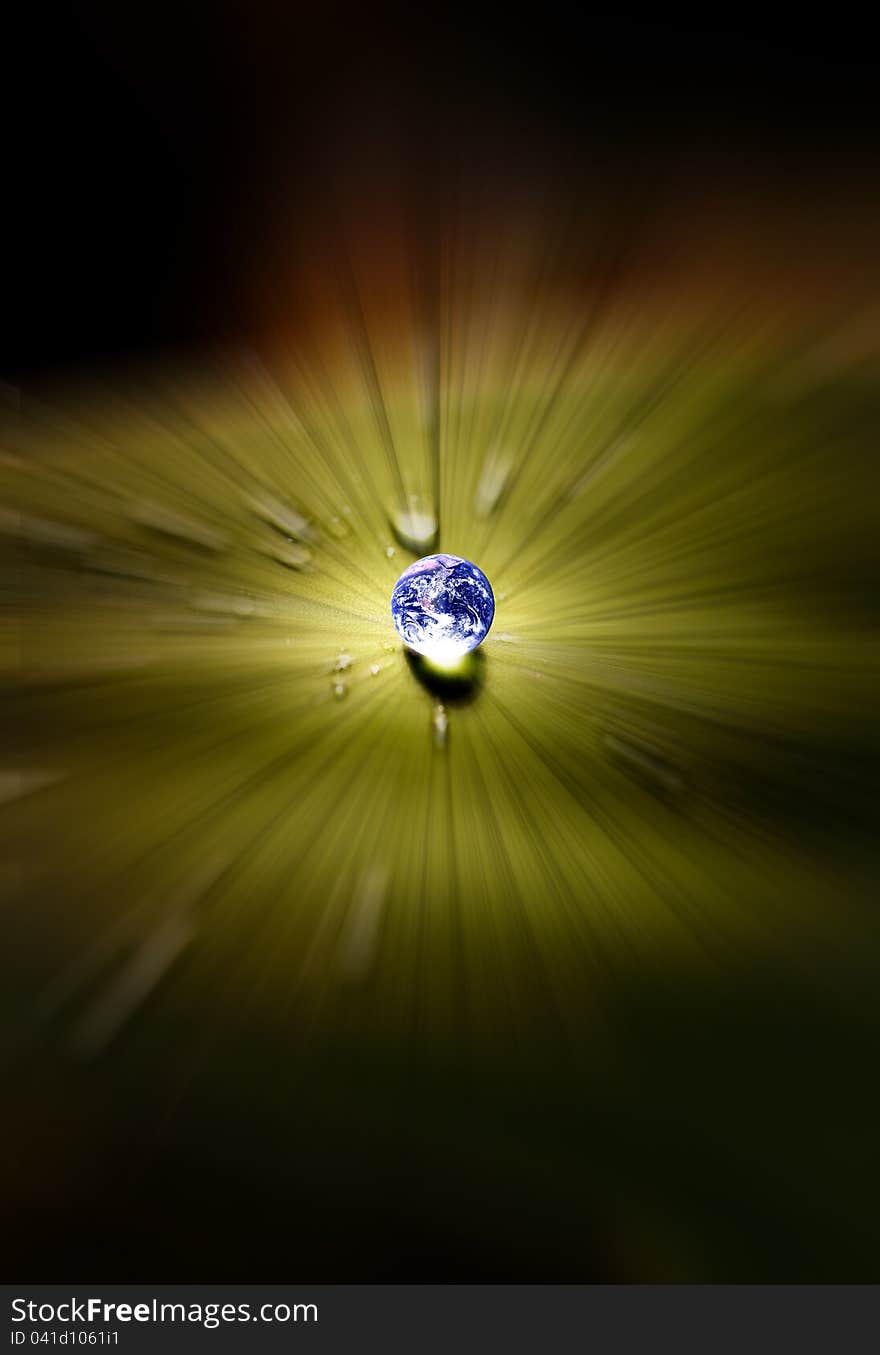 Planet earth waterdrop on leaf glowing in sunlight.