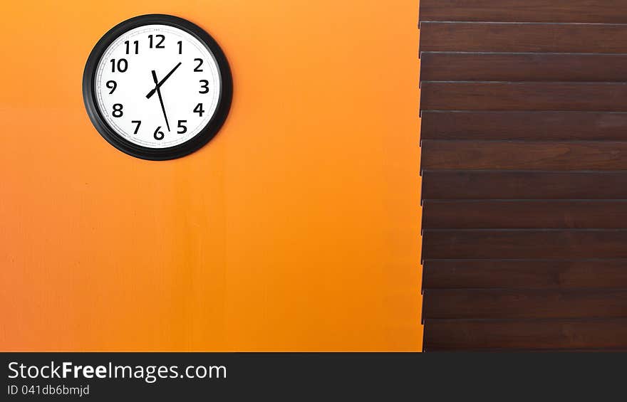 Wall clock on orange wall in afternoon. Wall clock on orange wall in afternoon