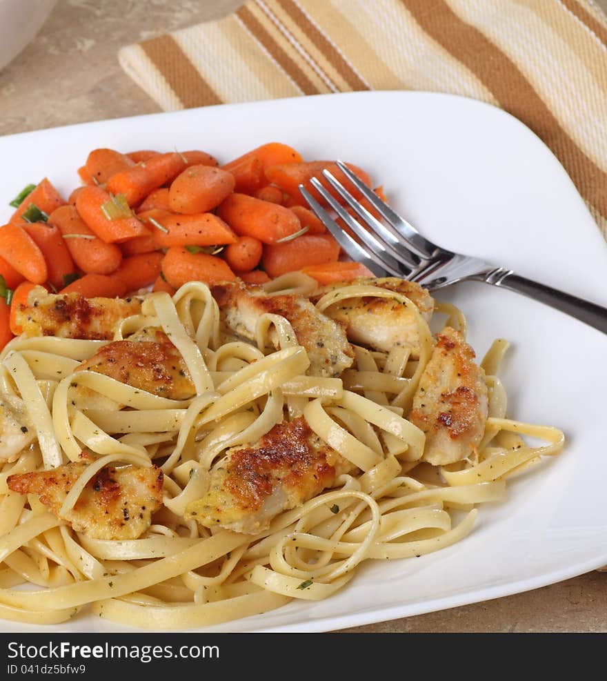 Chicken strips on top of noodles with carrots. Chicken strips on top of noodles with carrots