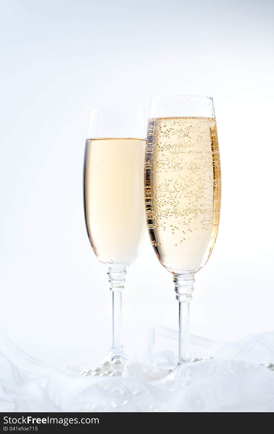 Two glasses of champagne on white fabric