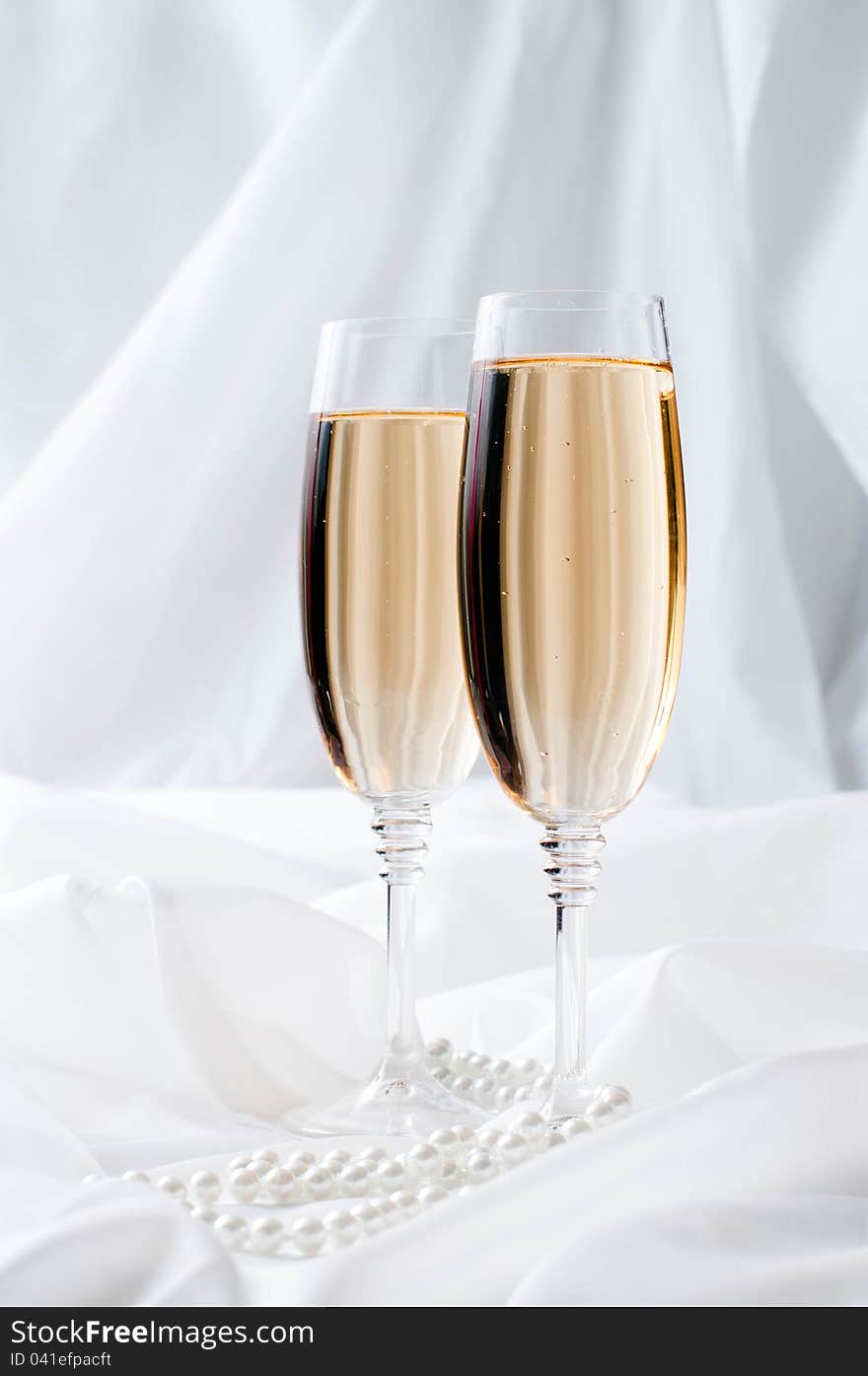 Two glasses of champagne on white fabric