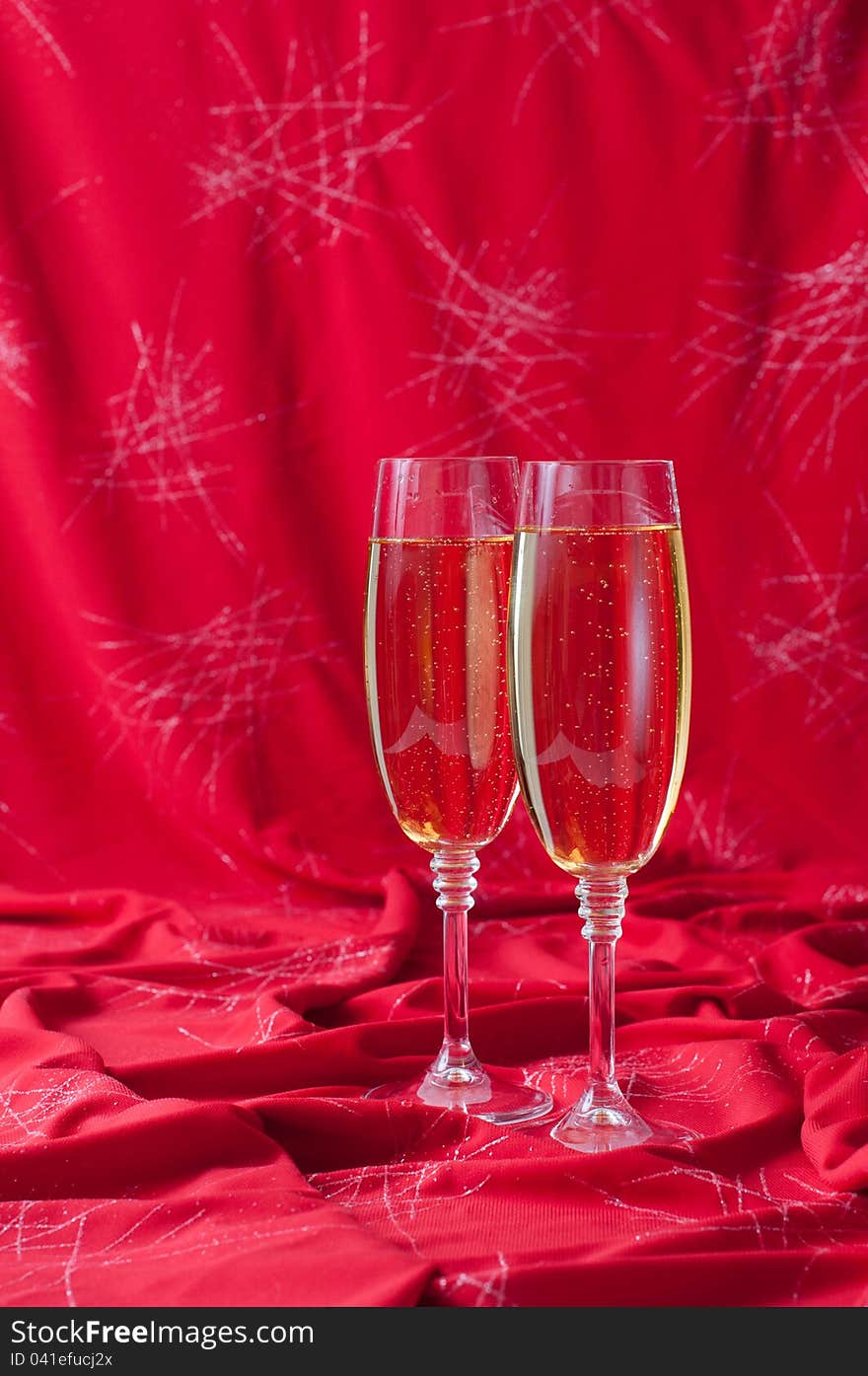 Two glasses of champagne on red fabric