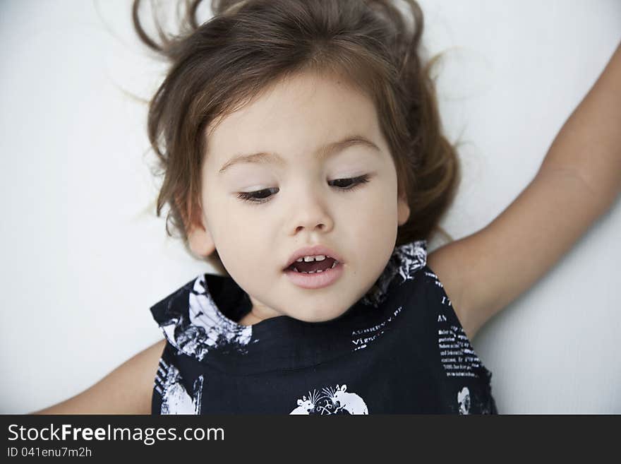 Portrait of a three-year girl who looks down