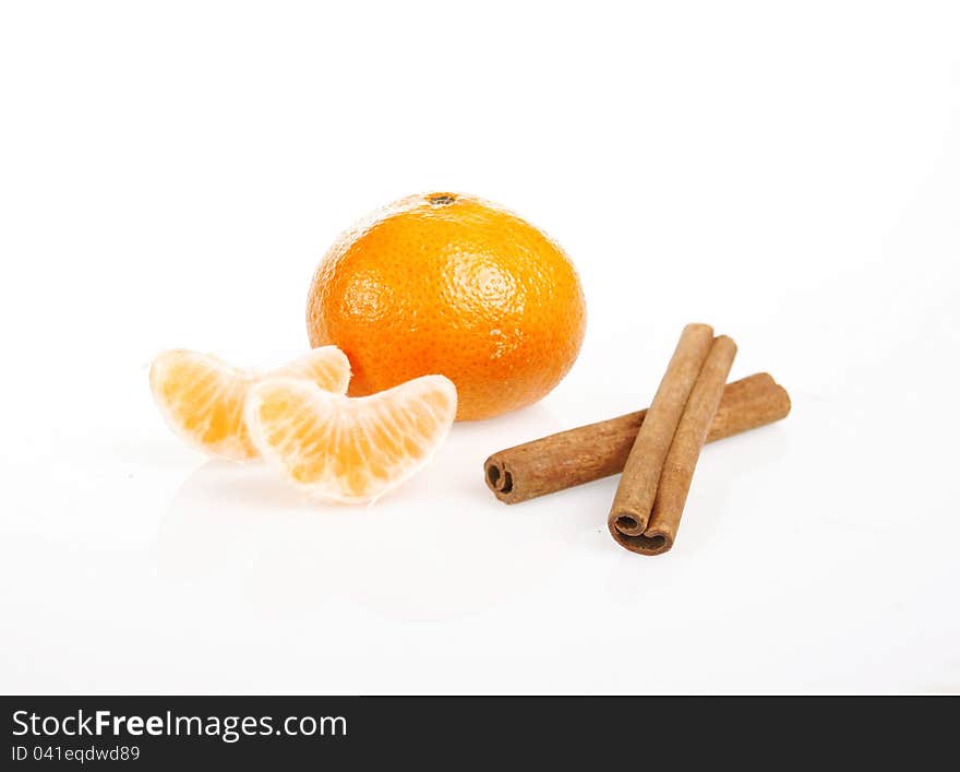 Tangerine and cinnamon sticks on white background.