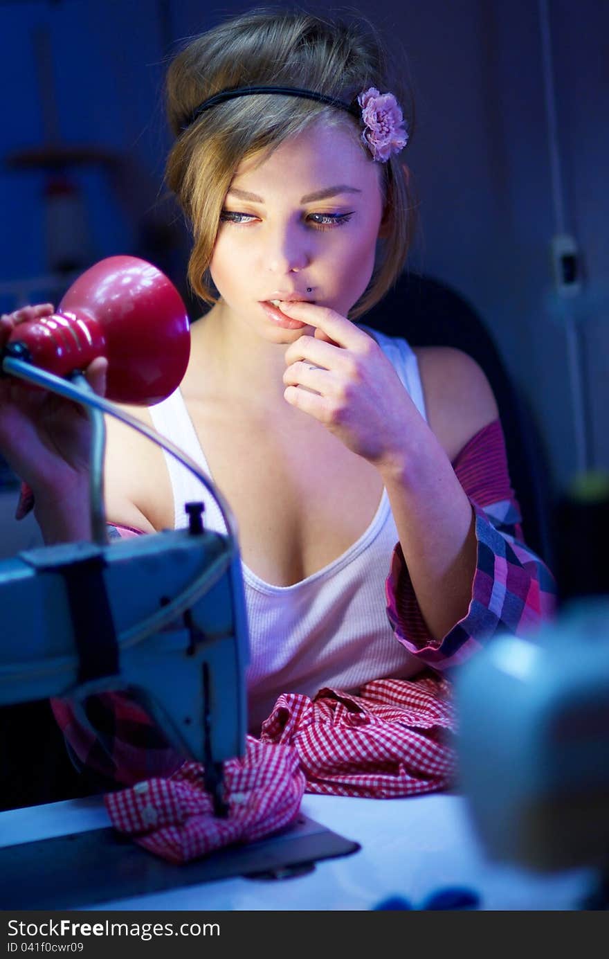 Seductive blond sewing in her workshop