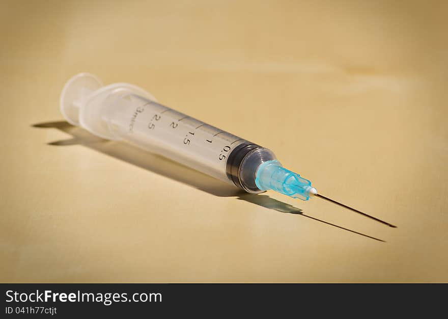 New empty disposable syringe on a beige background