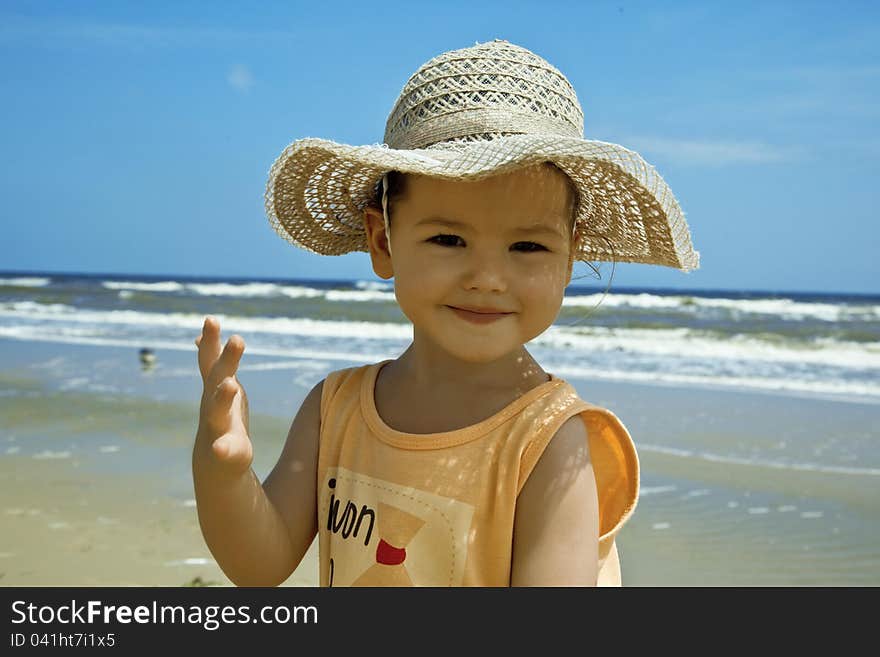 A child wearing a hat against the sea