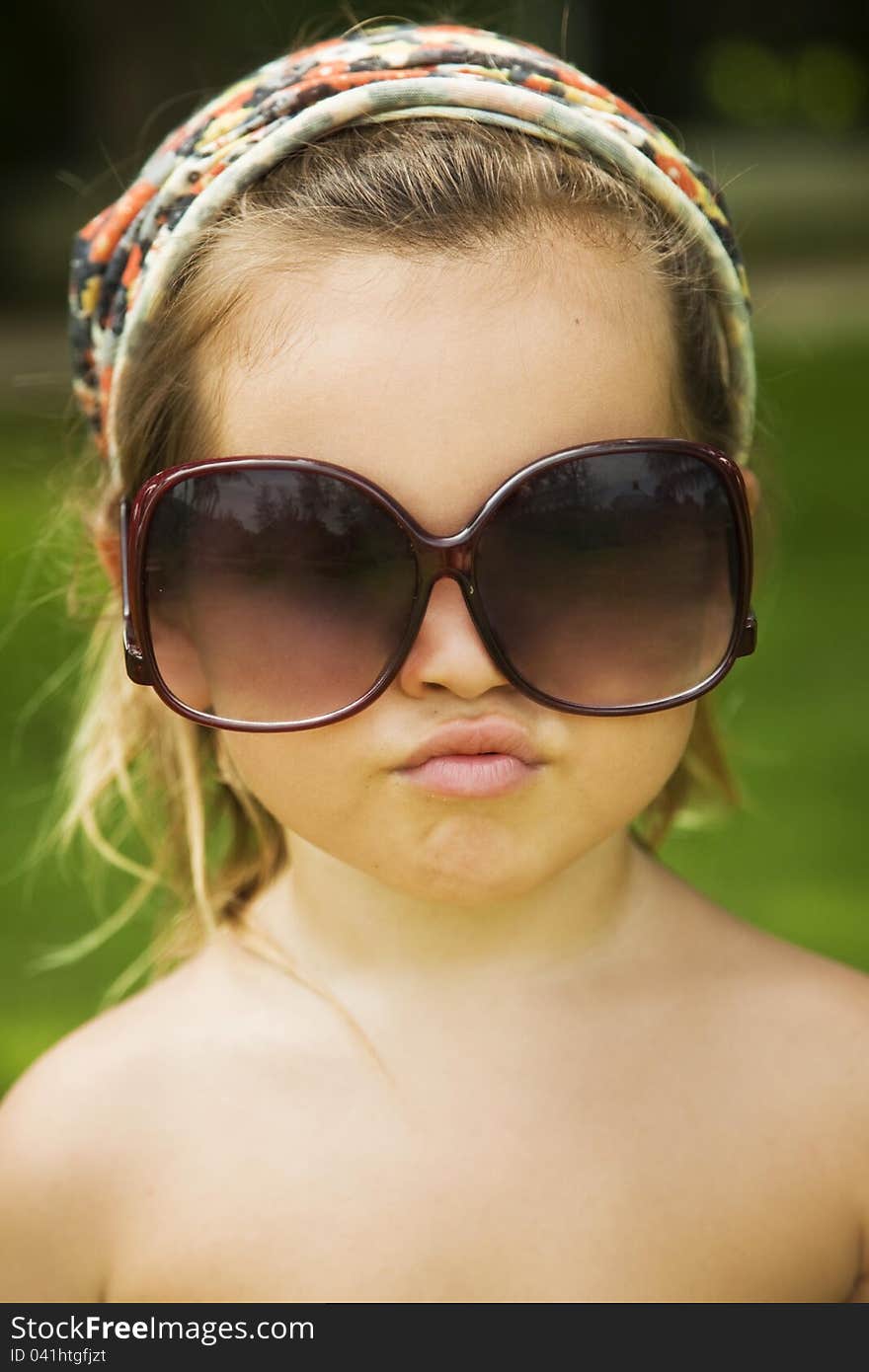 The Little Girl Wears A Large Adult Sunglasses