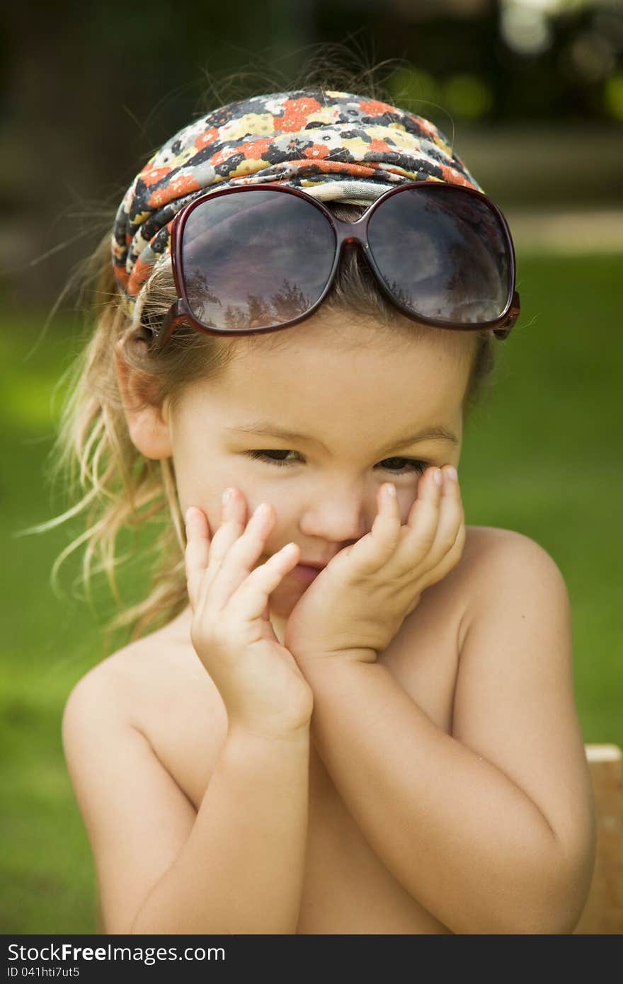 Girl wears a large adult sunglasses