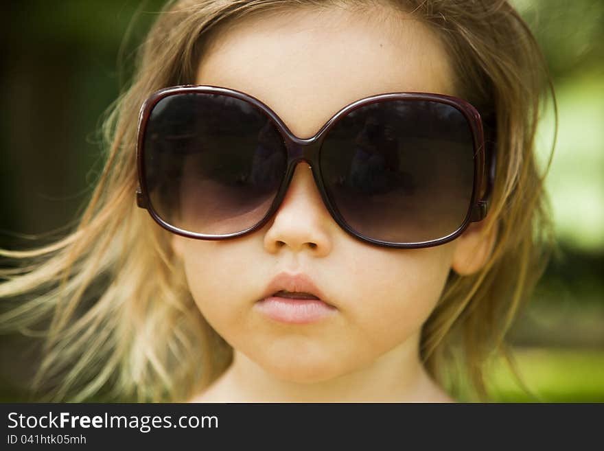 The little girl wears a large adult sunglasses, Asian-mestizo