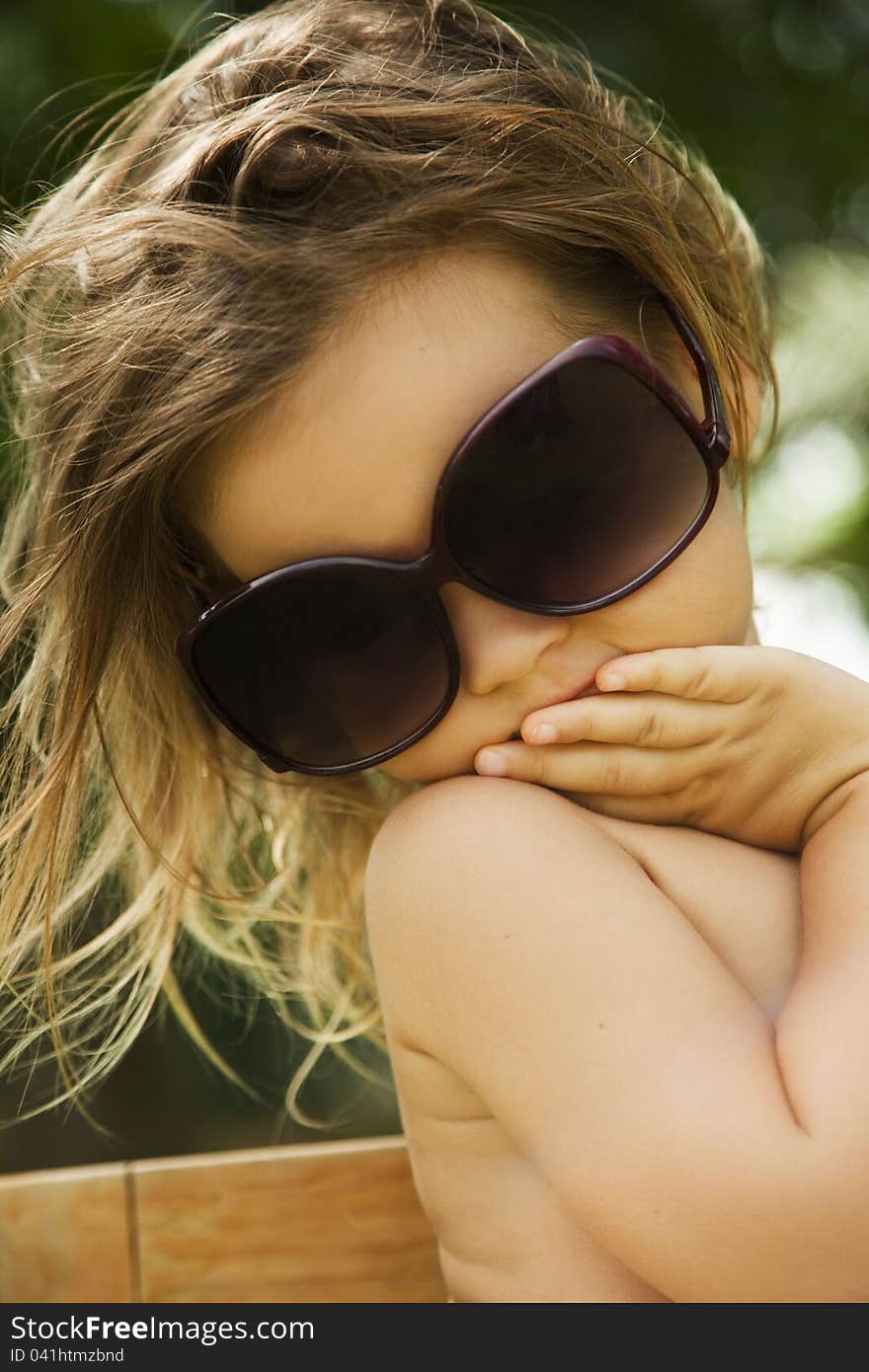 Girl wears a large adult sunglasses