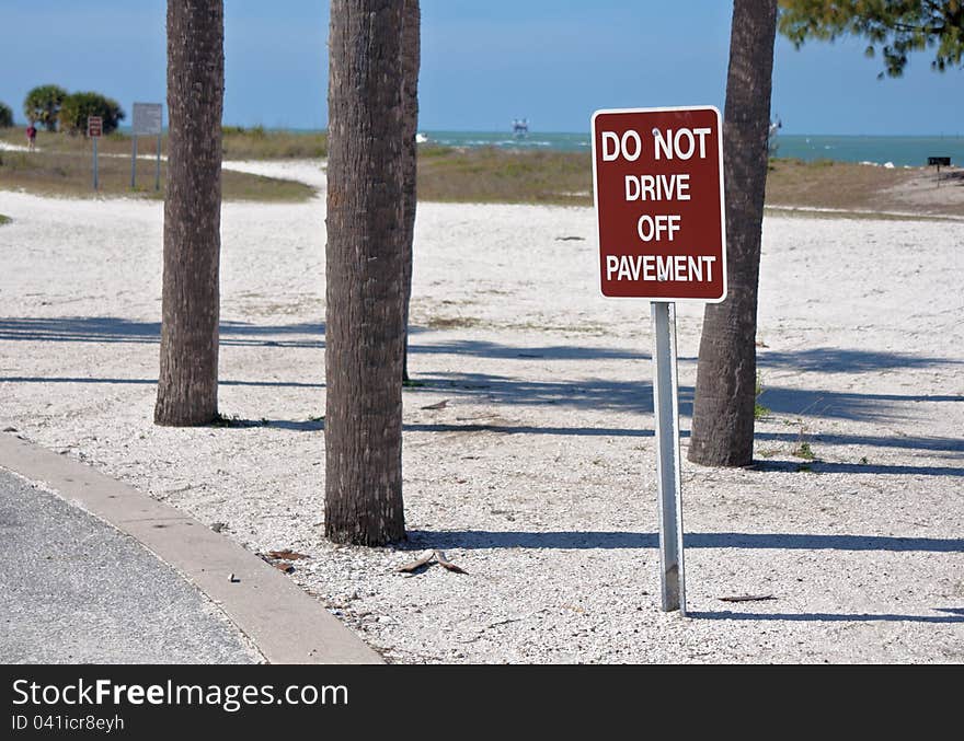 Do Not Drive Off Pavement sign, near the beach.