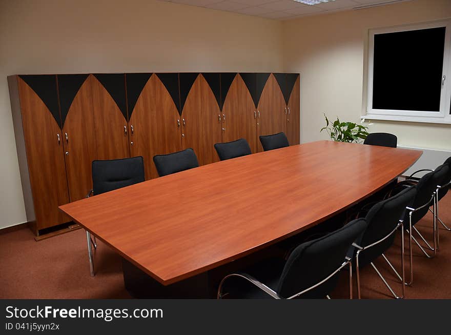 Meeting room with chairs cupboards and a table