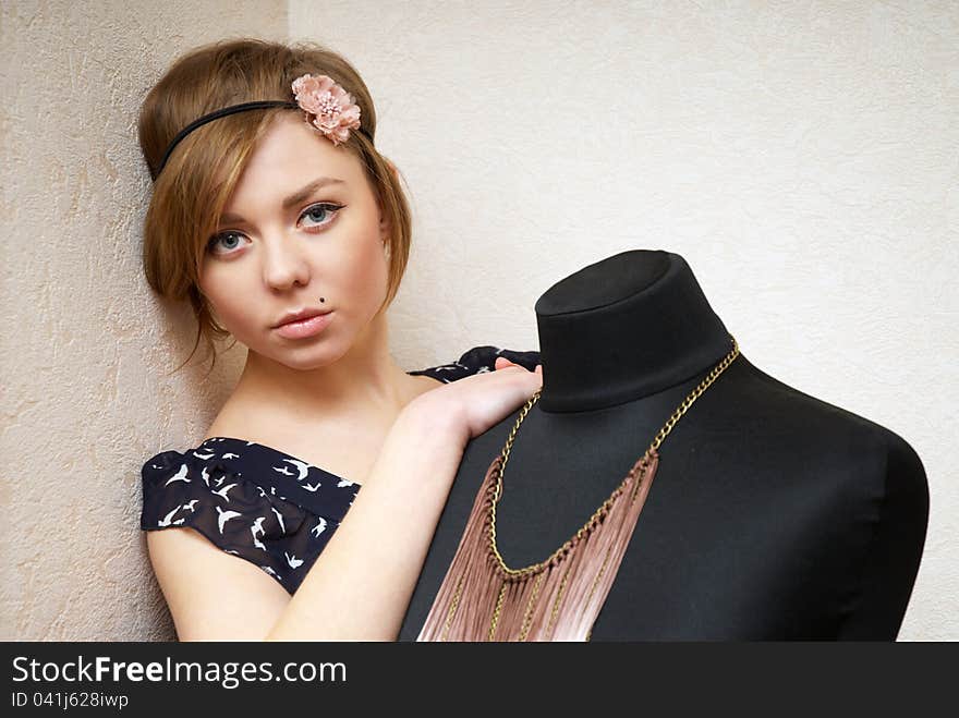 Girl posing near mannequin in seamstress's workshop