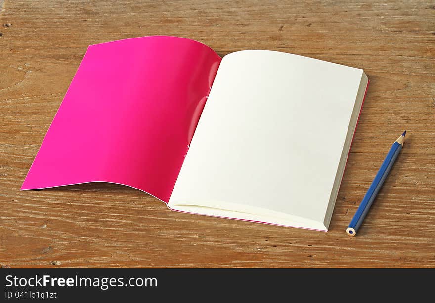 Red book with pencil on wooden background. Red book with pencil on wooden background