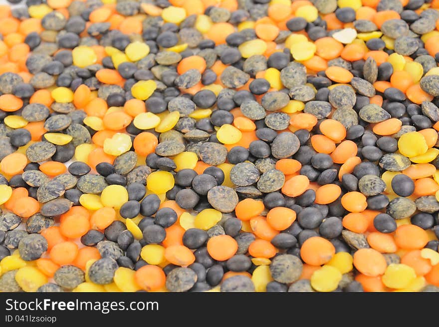 Black, orange and yellow lentils as a background