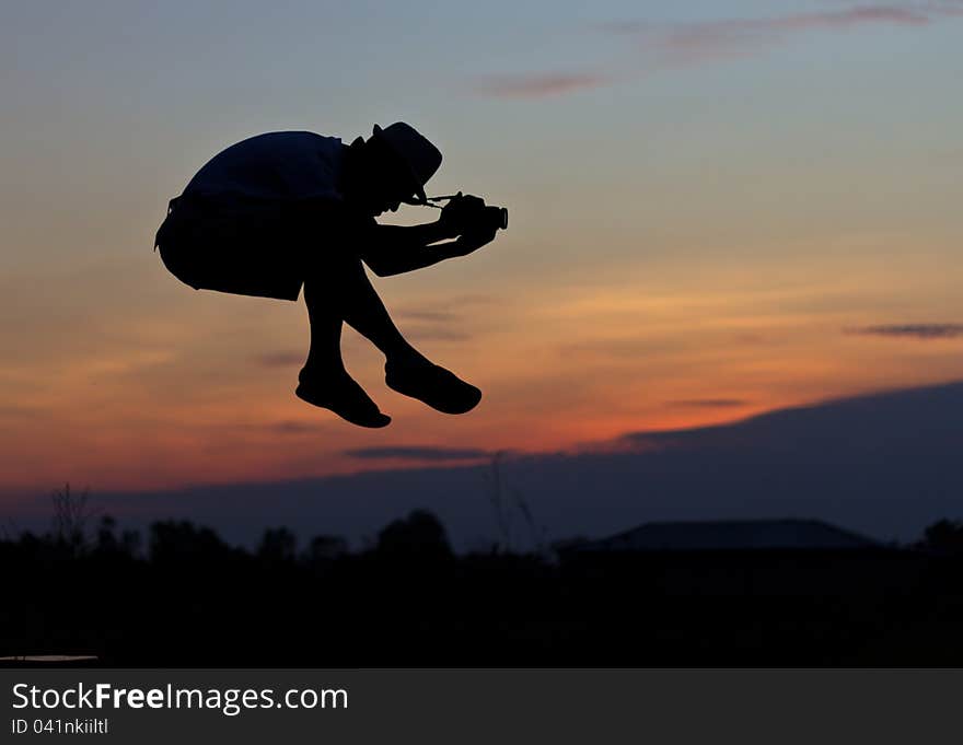 Silhouette of Jumping photographer shooting in the air. Silhouette of Jumping photographer shooting in the air.