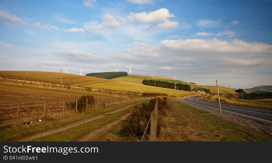 Wind turbines standing in a green field in Scotland. Wind turbines standing in a green field in Scotland.