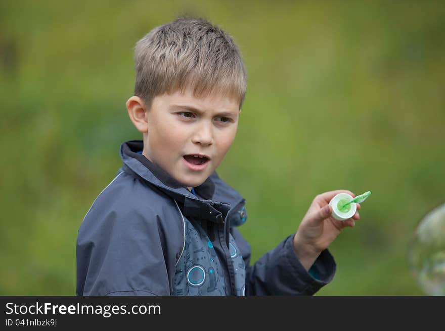 The boy starts up soap bubbles in countryside