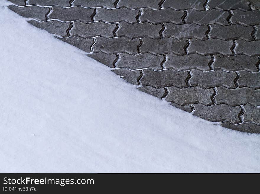 Grey brick wall partly covered by snow. Grey brick wall partly covered by snow.