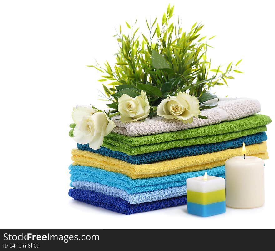 Spa towels with white rosesand burn candles isolated on white background