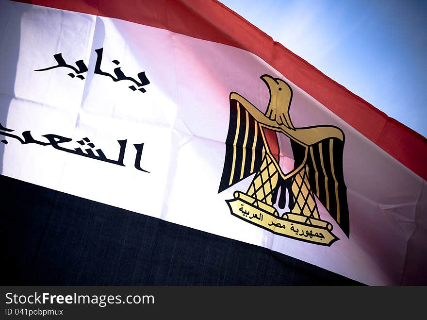 Egyptian flag in high dynamic range with blue sky in background , also the flag has the date of the egyptian revolution. Egyptian flag in high dynamic range with blue sky in background , also the flag has the date of the egyptian revolution