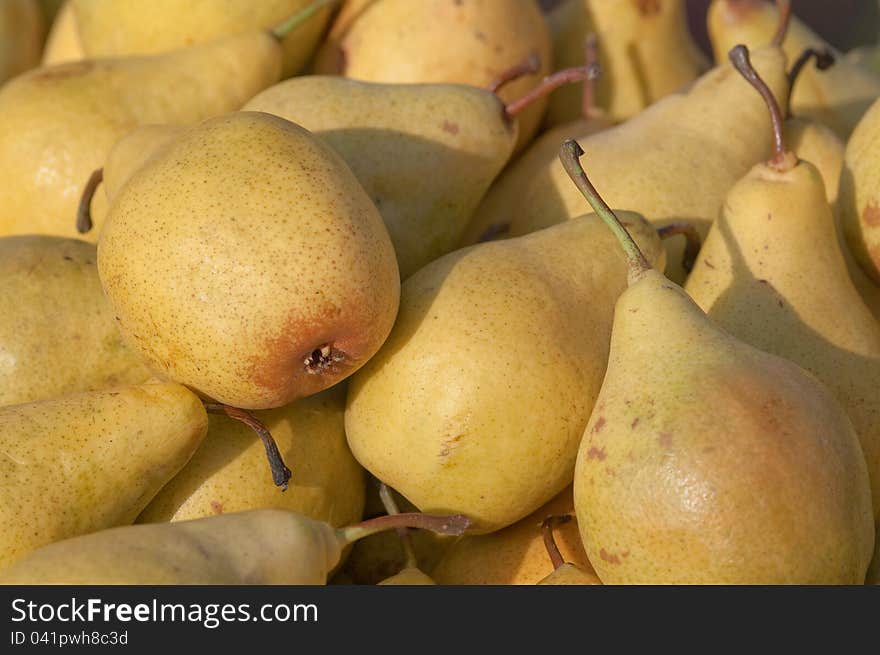 Yellow pears lined up on the counter for sale